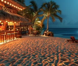 Caribbean-inspired beach bar with thatched roofs and sand floors.